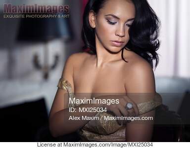 Sensual portrait of young woman undressing in bedroom... preview image