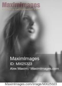 Young woman with angry expression behind glass... preview image