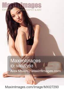 Sexy Japanese woman in bikini sitting against white wall... preview image