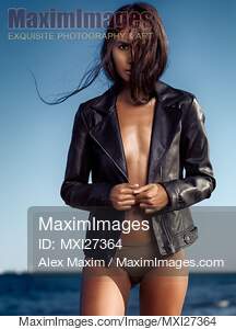 Sexy young woman in leather jacket at the beach... preview image