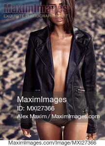 Sexy young woman at the beach wearing black leather jacket... preview image