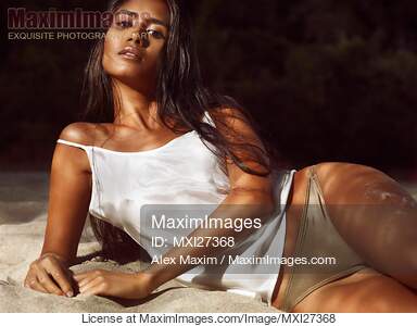 Sexy young woman lying on beach sand... preview image