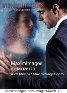 Couple separated by wet glass pane. Relationship drama...... preview image