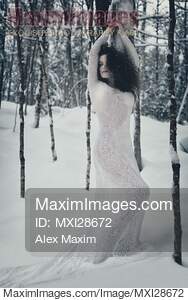 Woman in white lace dress in snowy winter nature scenery... preview image