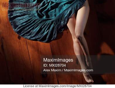 Sexy woman legs and green dress on wooden floor... preview image