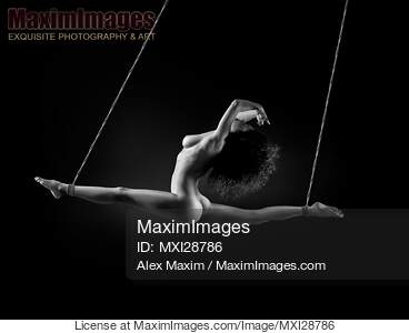 Beautiful nude woman suspended in a dynamic split by her...... preview image