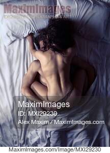 Couple making love in bed in dimly lit bedroom... preview image