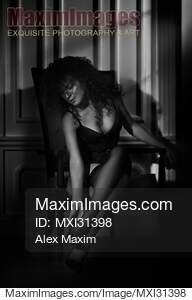Black and white sexy boudoir portrait of a woman sitting in...... preview image