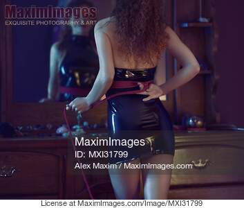 Woman in sexy black PU dress tying a bondage rope behind...... preview image