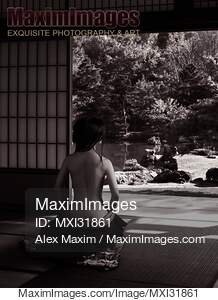 Japanese woman sitting in a house with Zen garden view with...... preview image