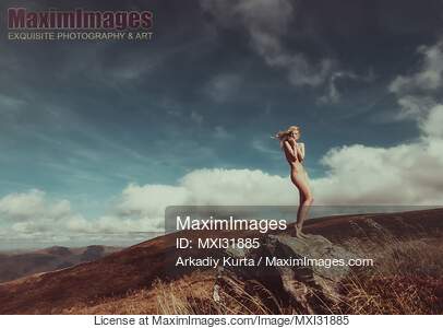 Nude woman standing gracefully on rocks in mountain...... preview image