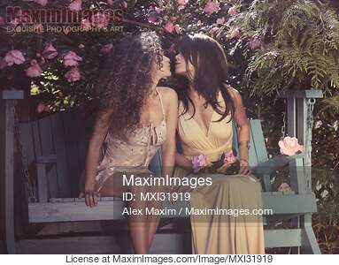 Two young women cute lesbian couple kissing on a bench in...... preview image