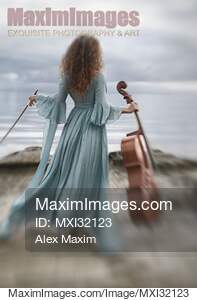 Woman in a long vintage dress standing gracefully by the...... preview image