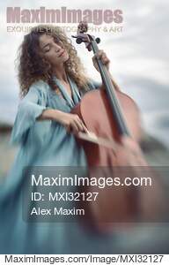 Beautiful young woman in a blue vintage dress passionately...... preview image