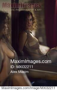 Sexy young woman in an unbuttoned dress sitting half...... preview image