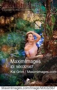 Beautiful sexy woman in swimsuit leaning against a rock in...... preview image