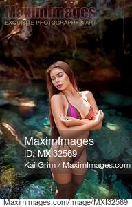 Sexy woman in bikini swimsuit standing in clear turquoise...... preview image