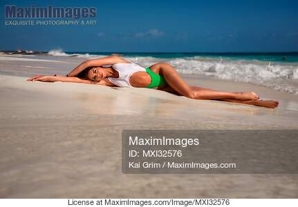 Sexy sun-tanned woman in a fashion bathing suit lying on...... preview image
