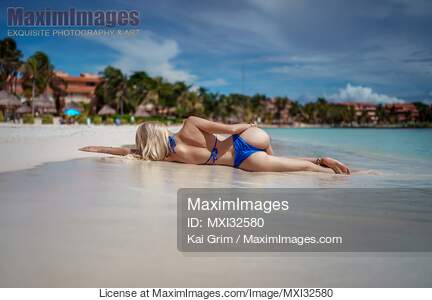 Rear view of a sexy woman in bikini swimsuit lying on a...... preview image