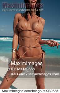 Closeup of a sexy woman in bikini tying swimsuit strings...... preview image