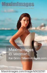 Sexy sun-tanned exotic woman at a beach covering her nude...... preview image