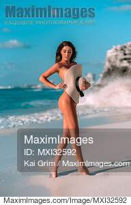 Sexy sun-tanned glamorous woman at a sandy beach covering...... preview image