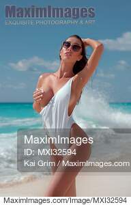 Sexy sun-tanned exotic woman at the beach in a swimsuit...... preview image