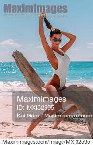 Sun-tanned exotic woman in swimsuit at a sandy sunny beach...... preview image