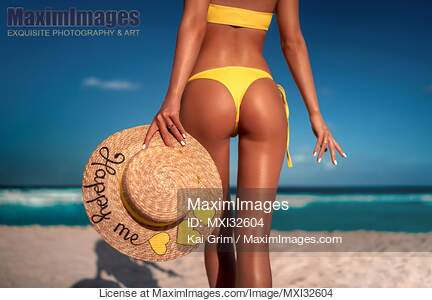 Sexy sun-tanned woman in a bright swimsuit with a straw sun...... preview image