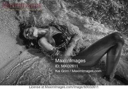 Beautiful sexy woman in swimsuit lying in sea water...... preview image
