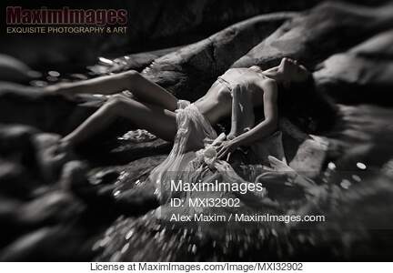 Beautiful nude woman lying on river rocks her naked barely...... preview image