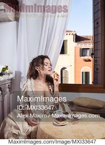 Beautiful elegant lady in Venetian carnival dress eating...... preview image