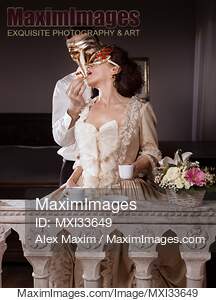 Sensual couple portrait of masked man tempting beautiful...... preview image