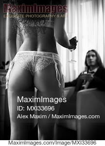 Back of a woman in sexy white lingerie approaching a man in...... preview image
