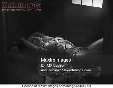 Beautiful nude woman lying on the floor tied up with...... preview image