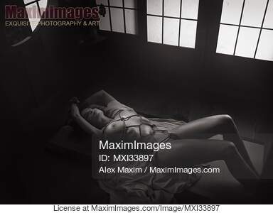 Beautiful nude woman lying on the floor tied up with red...... preview image