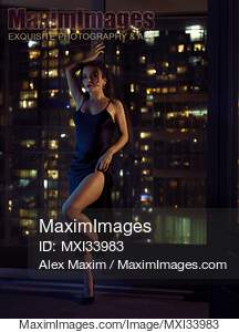 Beautiful sexy woman in black dress standing in a...... preview image