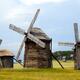 Group of old wooden windmills in field... (thumbnail)
