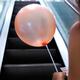 Woman with balloon on escalator... (thumbnail)