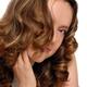 Young woman with curly hair covering her face... (thumbnail)
