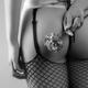 Sexy woman in fishnet stockings holding flower behind her back... (thumbnail)