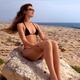 Beautiful young woman in bikini on rocky seashore... (thumbnail)