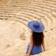 Woman sitting alone on steps of historic amphitheatre... (thumbnail)