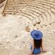 Young woman sitting alone on steps of historic amphitheatre... (thumbnail)