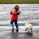 Child playing with dog in the rain... (thumbnail)