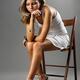Attractive Thoughtful Young Woman Sitting on a Chair... (thumbnail)