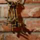 Bunch of antique keys on brick wall... (thumbnail)