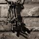 Bunch of antique keys on brick wall black and white... (thumbnail)