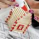 Woman Building a House from Matches... (thumbnail)