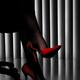 Woman in office with legs in black stockings and sexy red high-heel sh... (thumbnail)